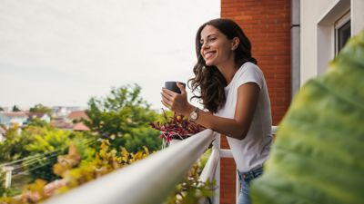 A woman holding a mug on a balcony